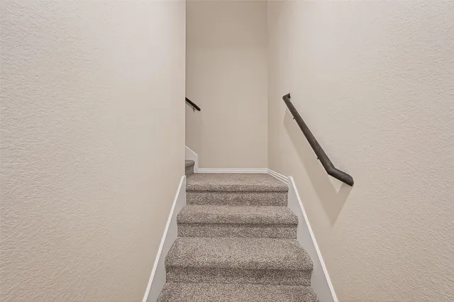 a view of staircase with white walls and white door