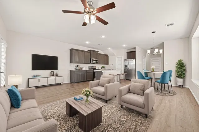 a living room with furniture kitchen view and a flat screen tv