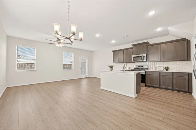 a view of kitchen with sink microwave and cabinets