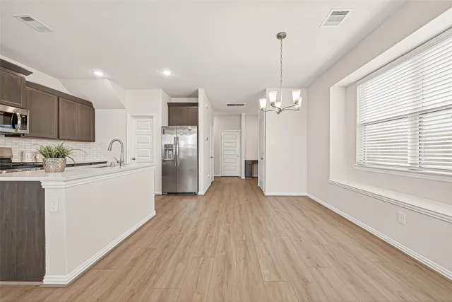 a kitchen with stainless steel appliances a refrigerator sink and microwave