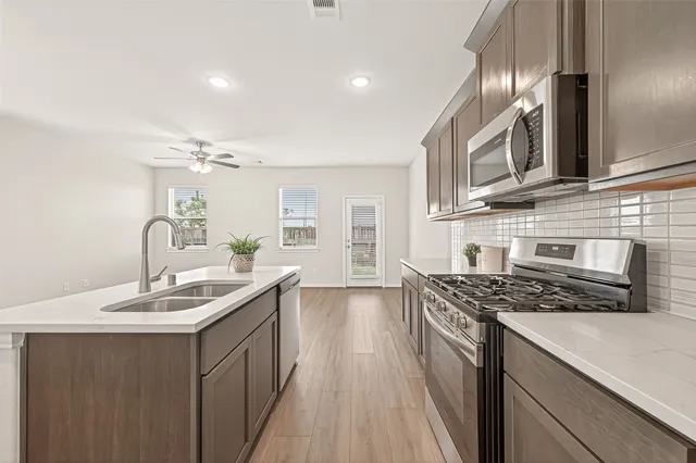 a kitchen with stainless steel appliances a sink stove and cabinets