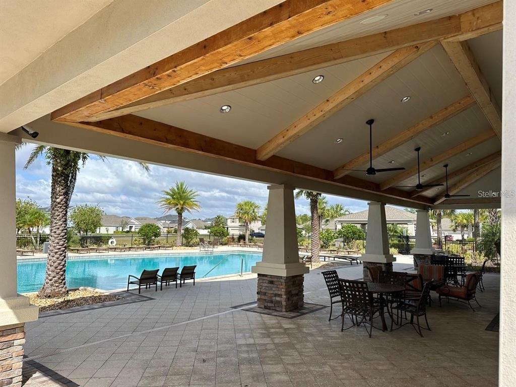 12254 Sandy Apple Road Orlando, FL 32824 - Photo 13 of 14 a view of a patio with table and chairs and couches with wooden floor