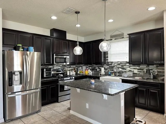 a kitchen with a sink and stainless steel appliances
