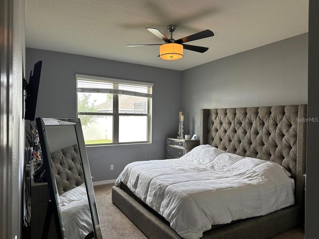 12254 Sandy Apple Road Orlando, FL 32824 - Photo 5 of 14 a bedroom with a bed and a chandelier