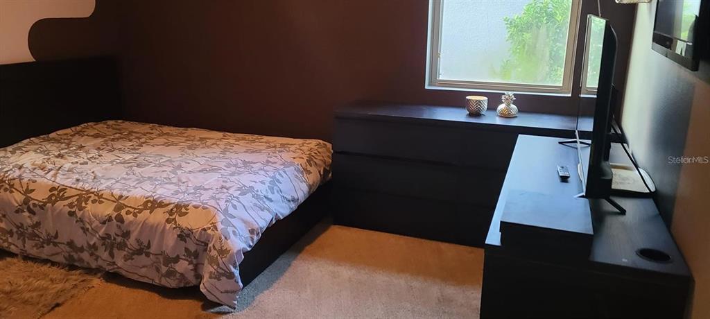 12254 Sandy Apple Road Orlando, FL 32824 - Photo 7 of 14 a bedroom with a bed and a window