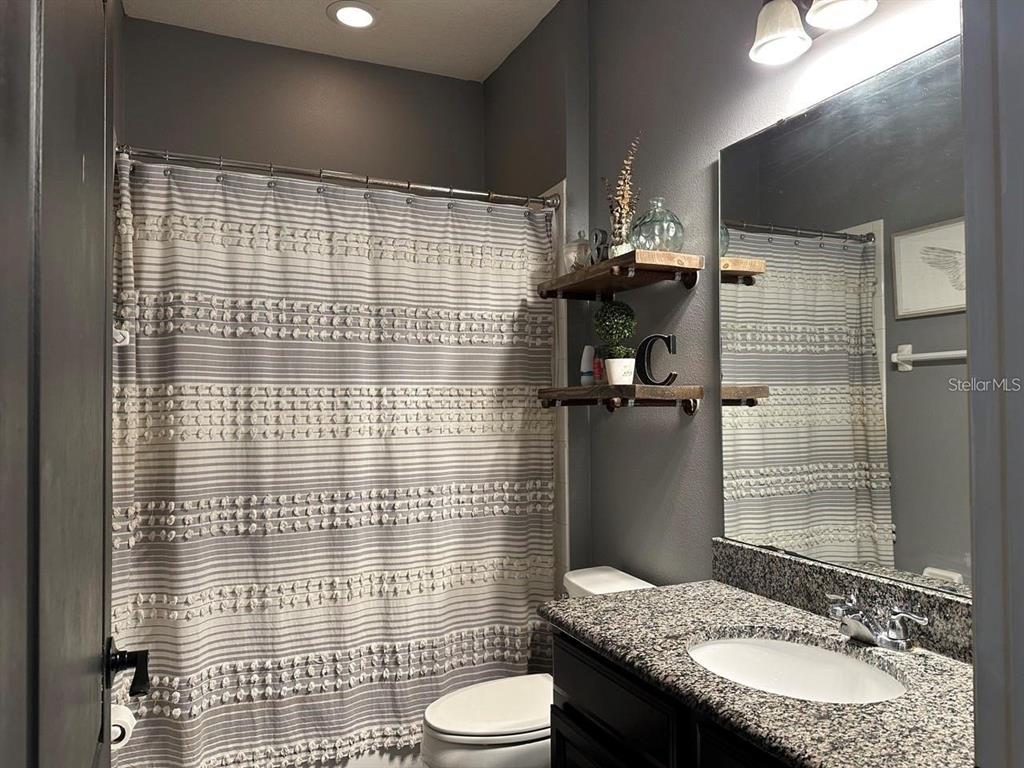 12254 Sandy Apple Road Orlando, FL 32824 - Photo 9 of 14 a bathroom with a granite countertop sink toilet and shower