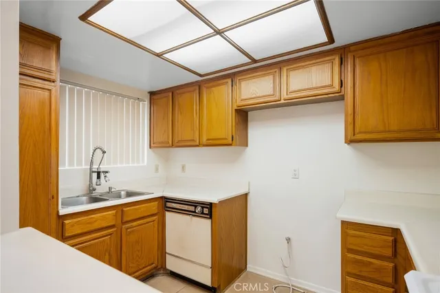 a kitchen with stainless steel appliances granite countertop a sink window and cabinets
