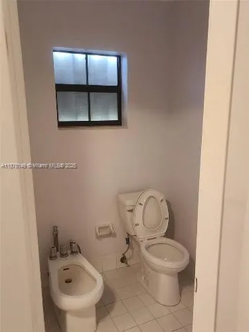 a white toilet sitting next to a bathroom sink