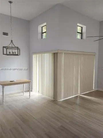 a view of a livingroom with wooden floor and a potted plant