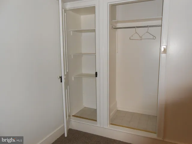 a view of an empty room with brick wall and a window