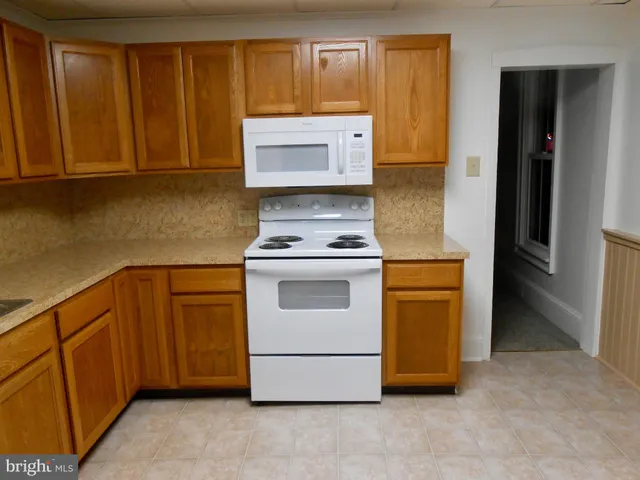 a kitchen with wooden floor and window