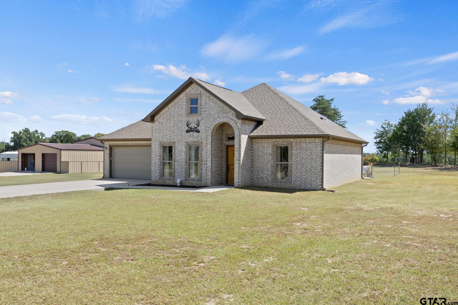 a view of a house with yard and garage