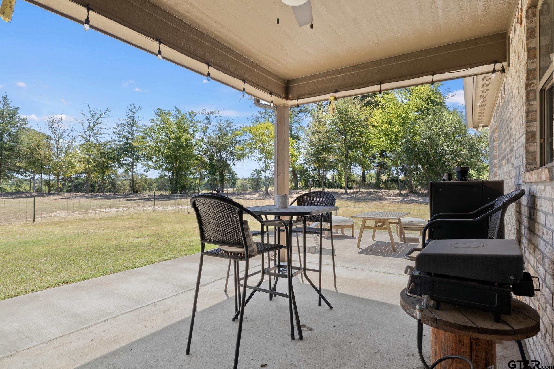 25 Private Road Pittsburg, TX 75686 - Photo 24 of 29 a view of a patio with table and chairs and couches with wooden floor and fence