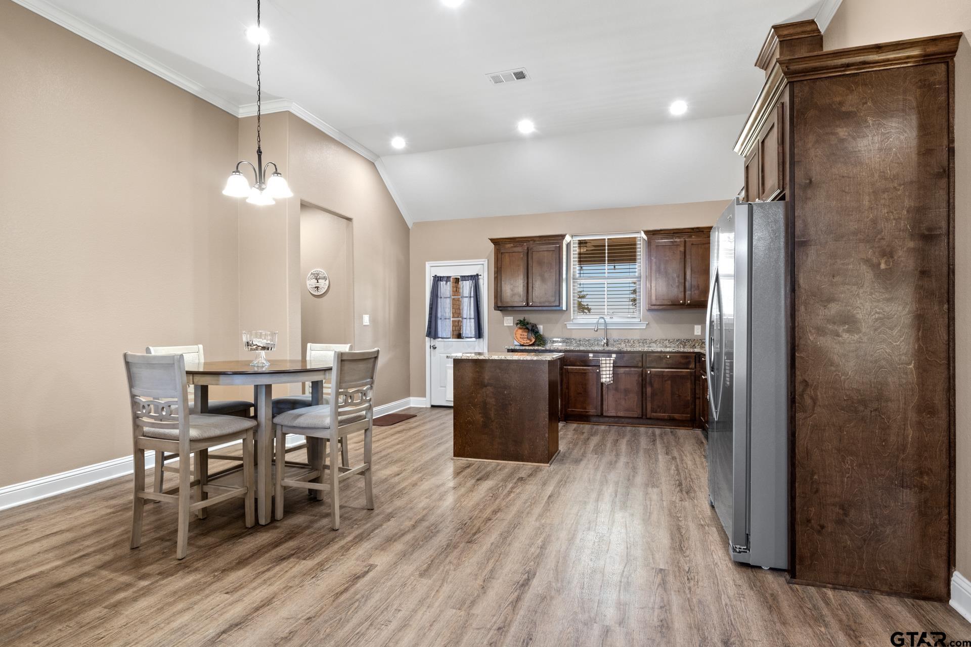 25 Private Road Pittsburg, TX 75686 - Photo 8 of 29 a kitchen with a table chairs refrigerator and cabinets