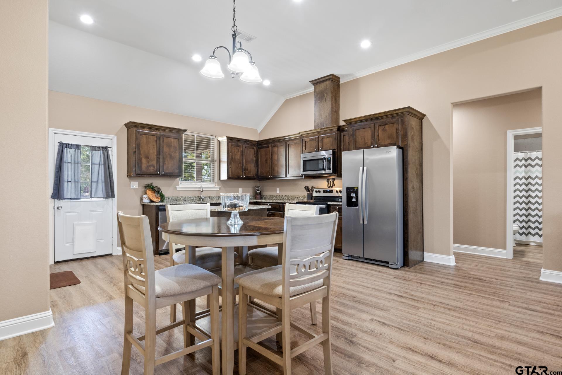 25 Private Road Pittsburg, TX 75686 - Photo 9 of 29 a kitchen with stainless steel appliances a dining table chairs refrigerator and microwave