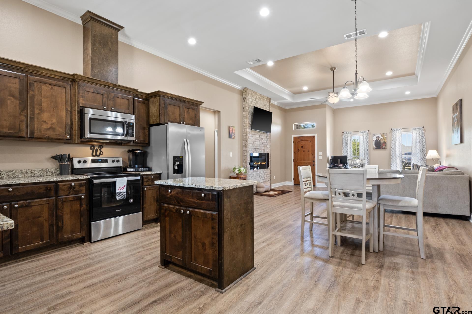 25 Private Road Pittsburg, TX 75686 - Photo 10 of 29 a kitchen with stainless steel appliances granite countertop wooden floors a stove a sink and a refrigerator