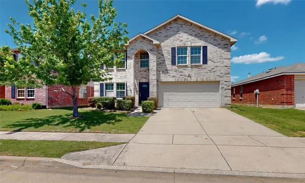 a front view of a house with a yard and a garage
