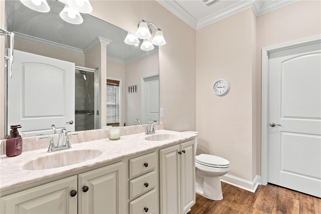 525 Shirley Store Road Anderson, SC 29621 - Photo 18 of 46 Crisp crown molding accents this restroom featuring a double vanity and rich wood flooring.