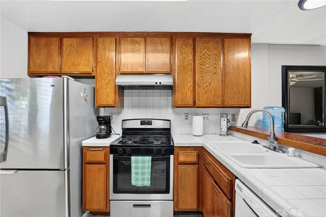 a kitchen with stainless steel appliances granite countertop a sink stove and cabinets