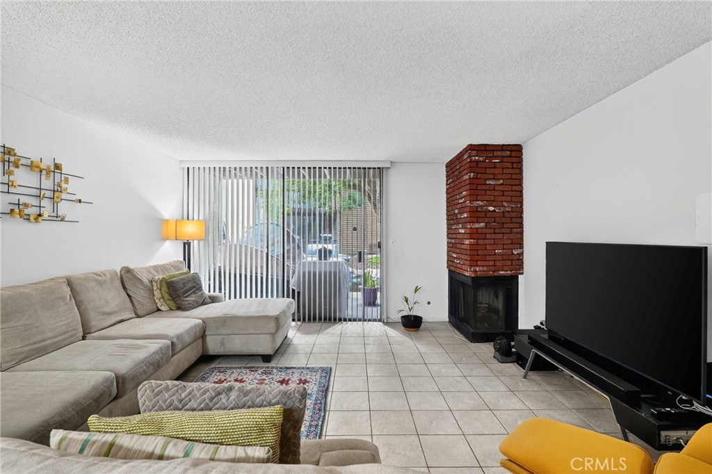 4140 Workman Mill Road, Unit 26 Whittier, CA 90601 - Photo 9 of 30 a living room with furniture a flat screen tv and a fireplace