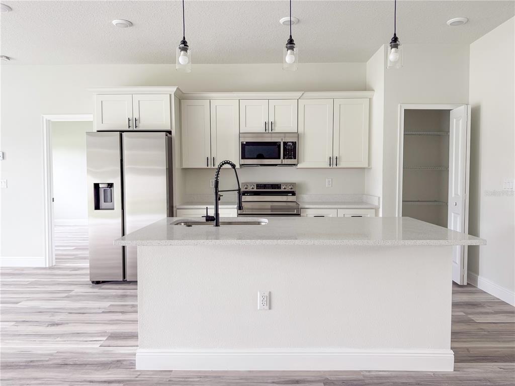 15716 Southwest 46th Ave Road Ocala, FL 34473 - Photo 12 of 31 a kitchen with kitchen island a counter top space a sink stainless steel appliances and cabinets