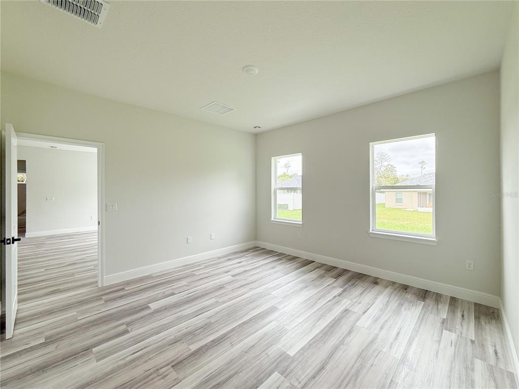 15716 Southwest 46th Ave Road Ocala, FL 34473 - Photo 23 of 31 a view of an empty room with wooden floor and a window