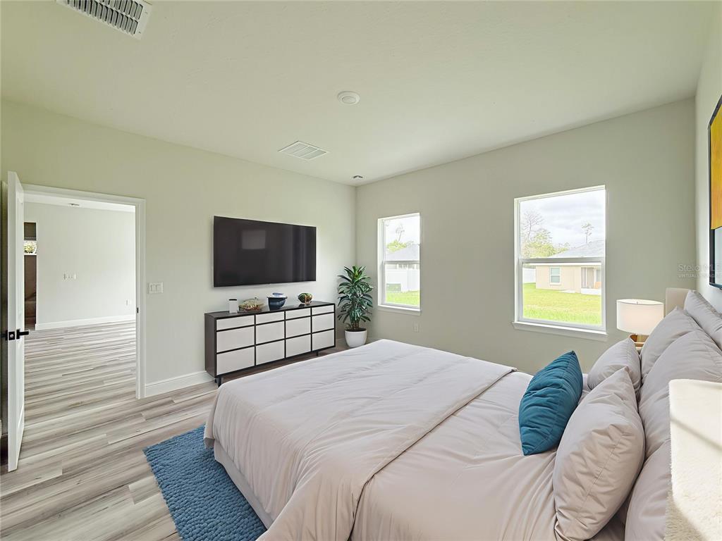 15716 Southwest 46th Ave Road Ocala, FL 34473 - Photo 30 of 31 a bedroom with a bed and a flat screen tv