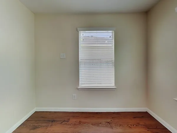 a view of a small space with wooden floor and a window