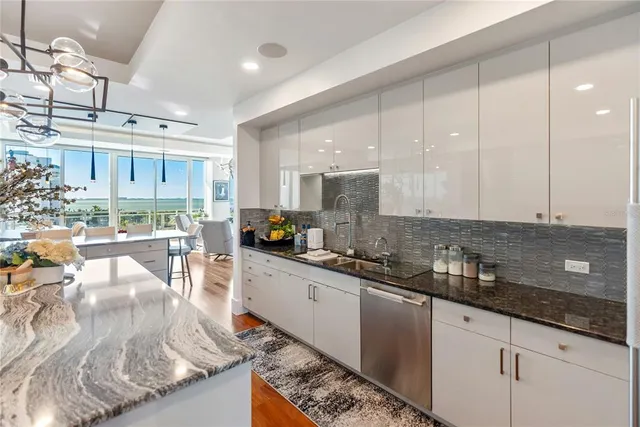 a living room with furniture kitchen view and a chandelier