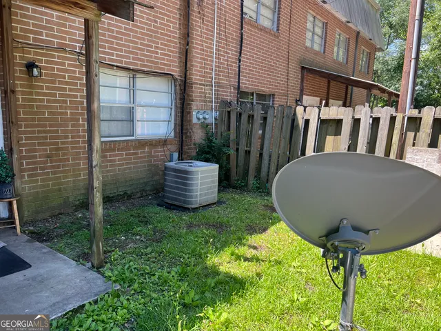 a view of a backyard with table and chairs potted plants and wooden fence
