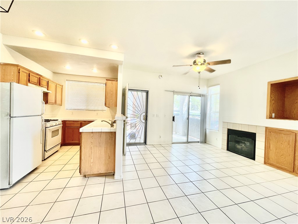 2201 Ramsgate Drive, Unit 915 Henderson, NV 89074 - Photo 21 of 36 An inviting open-concept layout connects the kitchen and living area, featuring a cozy fireplace.