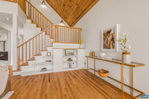 a view of a hallway with wooden floor and staircase