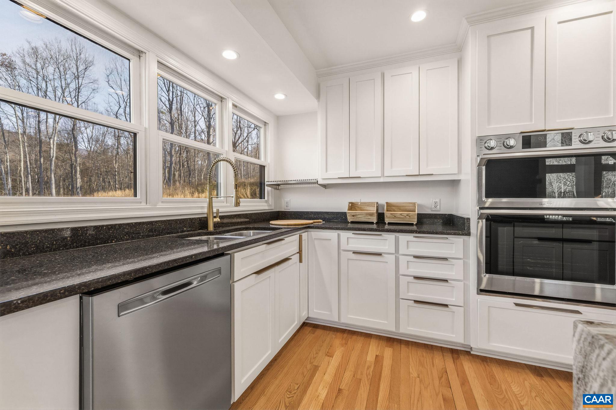 7102 Blackwells Hollow Road Crozet, VA 22932 - Photo 9 of 57 a kitchen with stainless steel appliances granite countertop a stove a sink and a microwave
