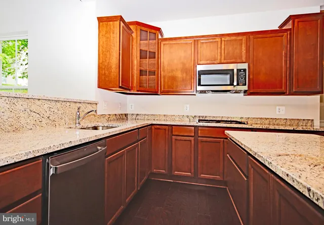 a kitchen with stainless steel appliances granite countertop a sink stove and microwave