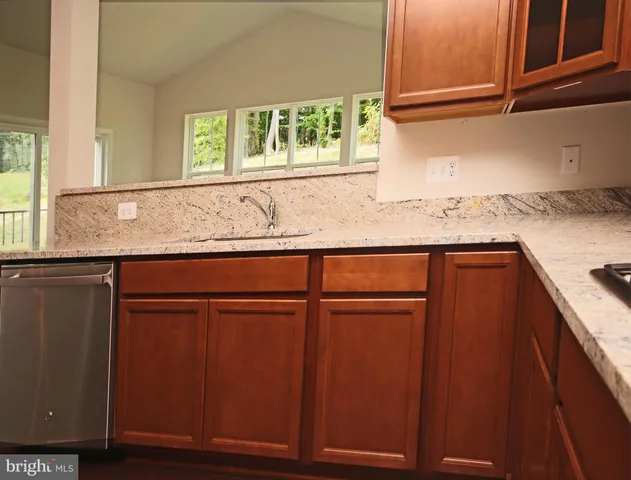 a kitchen with granite countertop cabinets sink and window