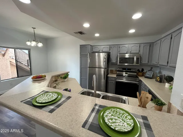 a kitchen with kitchen island stainless steel appliances a sink stove and refrigerator