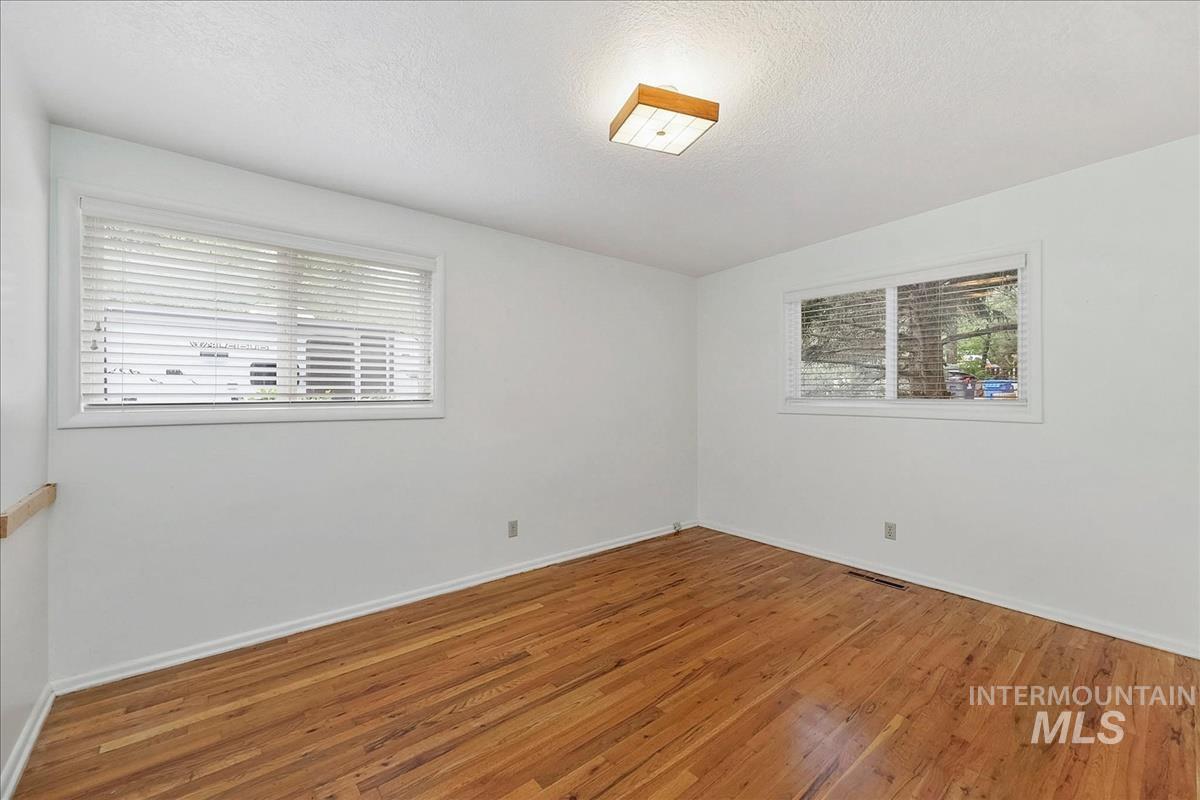 7141 West Hill Road Boise, ID 83714 - Photo 17 of 28 Room featuring wood flooring, white walls, and a window with blinds
