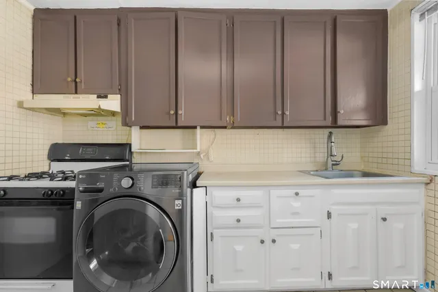 a kitchen with granite countertop cabinets and washer