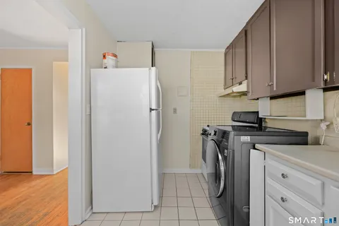 a view of a kitchen with a sink refrigerator and cabinets
