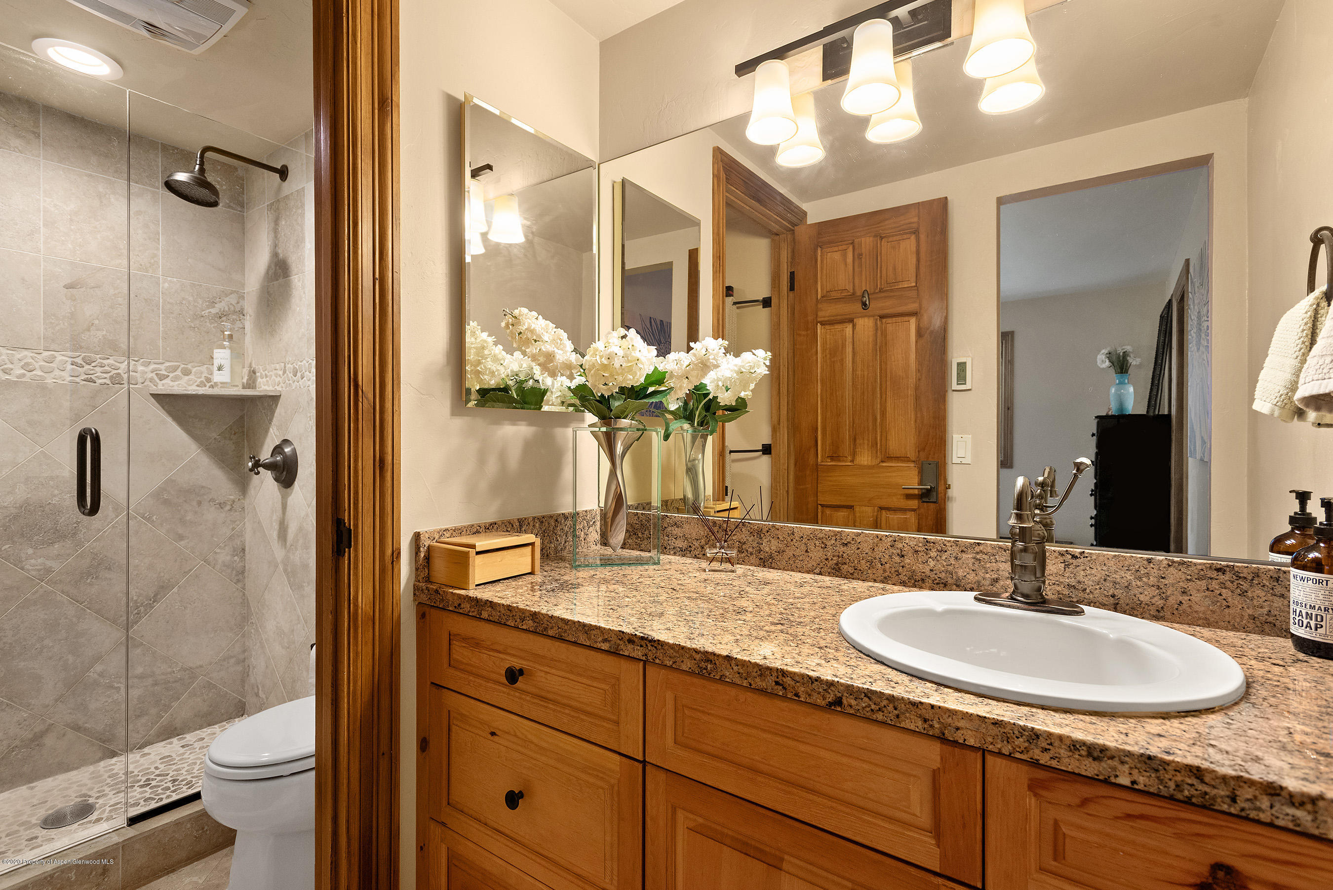 222 Meadow Ranch Road, Unit D4B Snowmass Village, CO 81615 - Photo 13 of 26 a bathroom with a granite countertop sink a mirror and a shower
