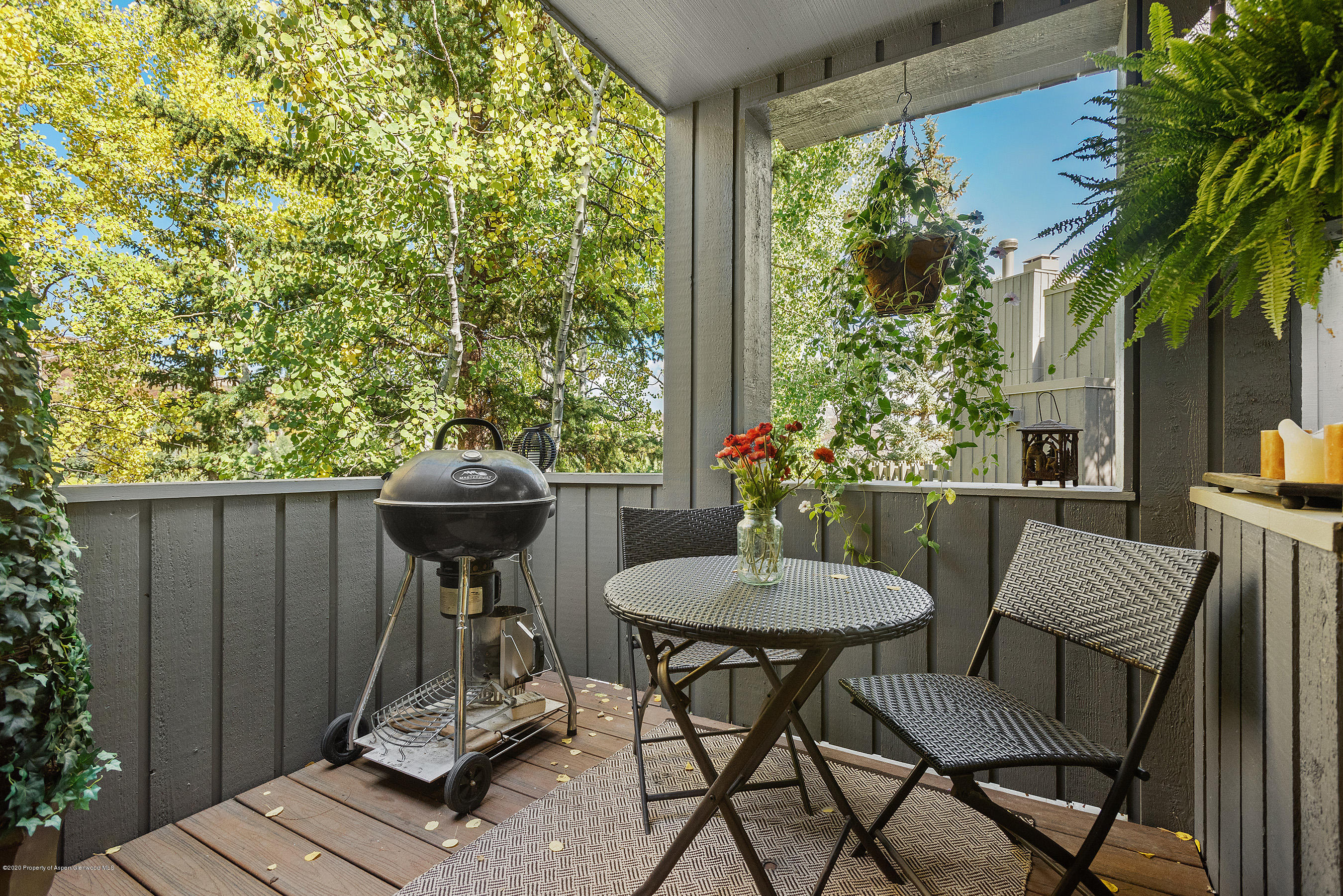 222 Meadow Ranch Road, Unit D4B Snowmass Village, CO 81615 - Photo 25 of 26 a view of a patio with table and chairs potted plants and floor to ceiling window
