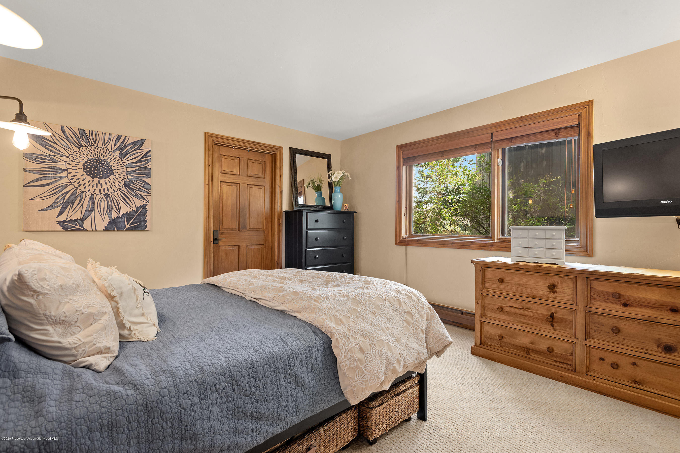 222 Meadow Ranch Road, Unit D4B Snowmass Village, CO 81615 - Photo 8 of 26 a bedroom with a bed and a dresser next to a window