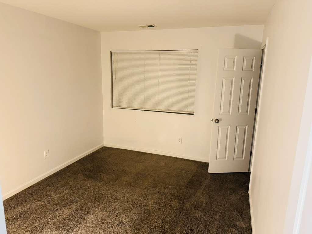 3759 Mulkey Circle Southwest Marietta, GA 30008 - Photo 19 of 22 an empty room with wooden floor and mirror