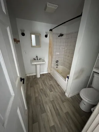 a view of an empty room with wooden floor