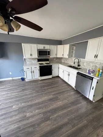 a kitchen with kitchen island granite countertop a sink cabinets and stainless steel appliances