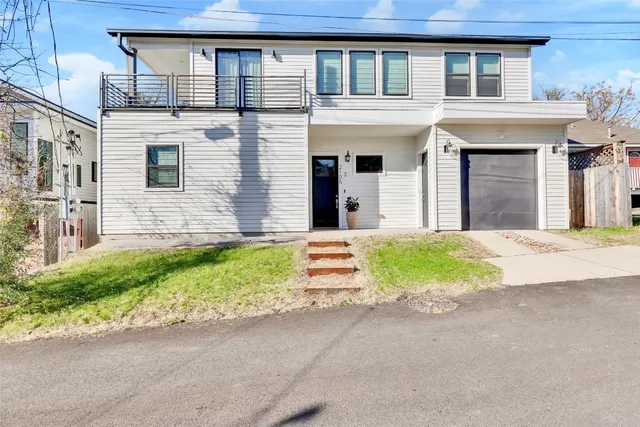 a front view of a house with a garden and yard