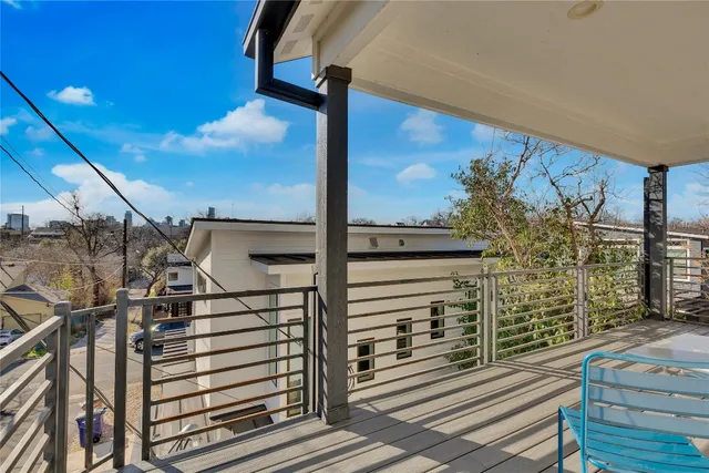 a view of a balcony with wooden floor and fence