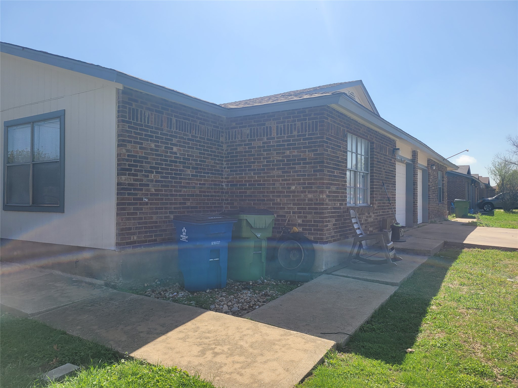 1011 Ridgemont Street Round Rock, TX 78664 - Photo 2 of 4 View of side of property featuring brick siding and a yard