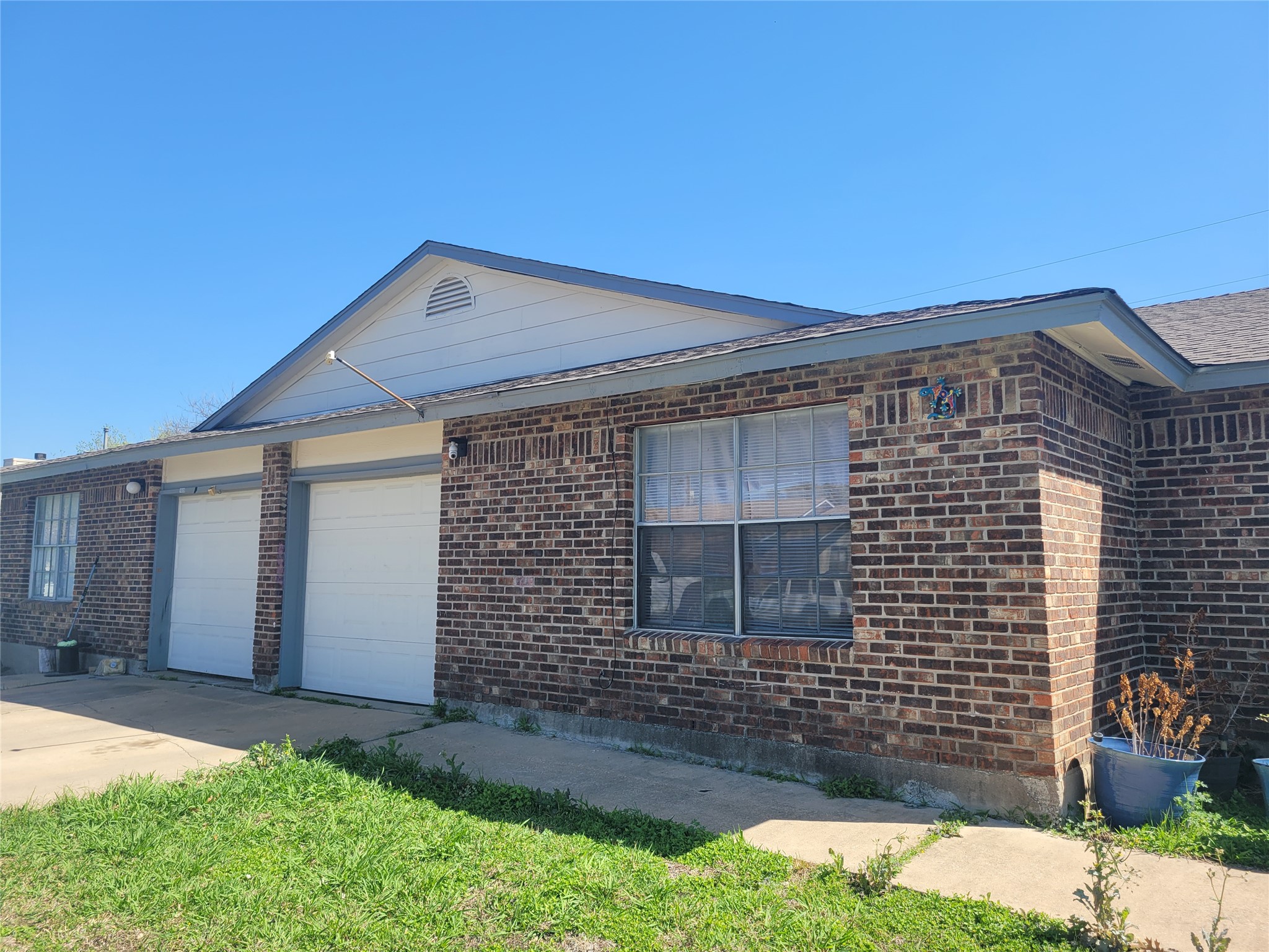 1011 Ridgemont Street Round Rock, TX 78664 - Photo 4 of 4 View of front facade with an attached garage, concrete driveway, and brick siding