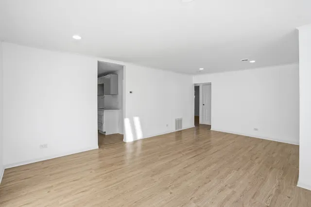 a view of an empty room with wooden floor